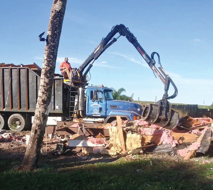 OKEECHOBEE COUNTY — Crew members from Maguire’s Bobcat Service and Maguire’s Hauling Inc., owned by Michael Maguire of Okeechobee, handle demolition of a decrepit old three-bedroom mobile home that was destroyed by tenants who brought illegal drug activity.